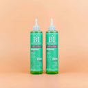 Photo publicitaire qualité studio, un lot de 2 flacons d'activateur de pousse beauté insolente présentés debout sur un fond neutre couleur pêche claire.