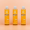  Photo publicitaire qualité studio, un lot de 3  flacons  de huile nutritive beauté insolente présentés debout sur un fond neutre couleur pêche claire.