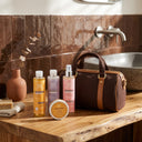 photo professionnelle lifestyle, ensemble de 4 produits capillaires beauté insolente routine pour les cheveux locksés, présenté à côté d'un sac de sport dans une salle de bain. 